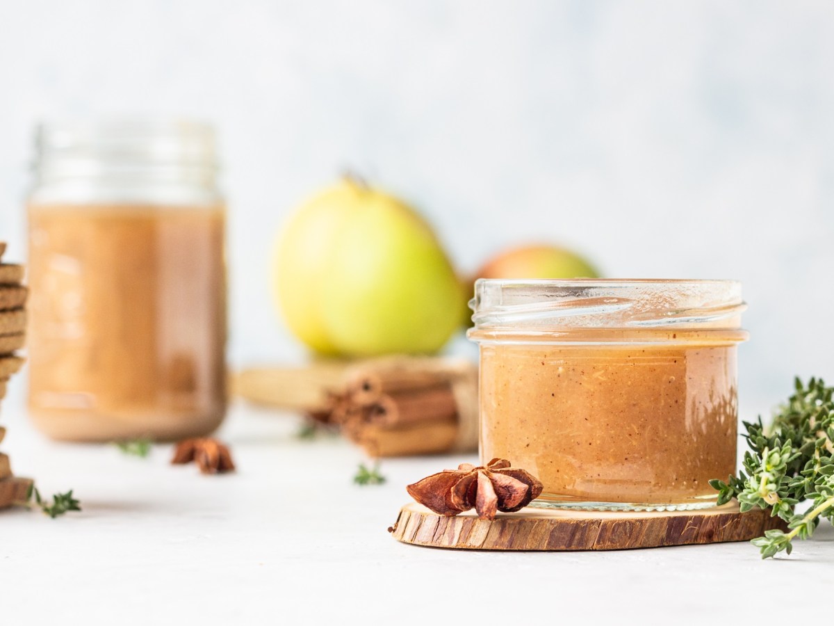 zwei Gläser weihnachtliche Birnenmarmelade mit weihnachtlichen Gewürzen daneben