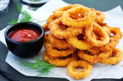 Ein Teller mit Zwiebelringen aus dem Airfryer.