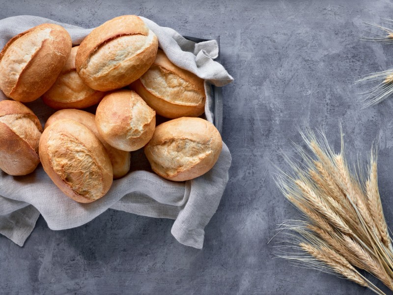 BrÃ¶tchen ohne Kneten: Ein Korb BrÃ¶tchen, daneben WeizenÃ¤hren