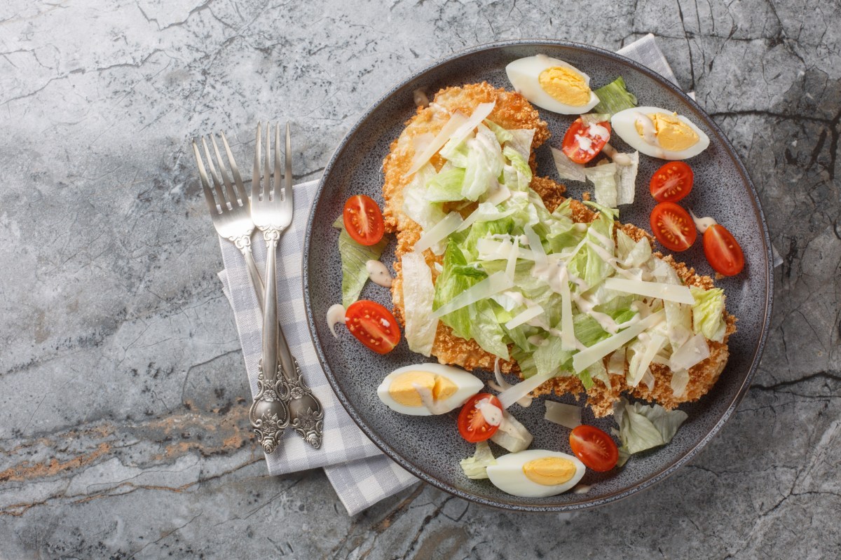 Teller mit Caesar-Salad-Schnitzel in der Draufsicht