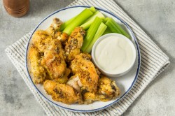 Lemon Pepper Wings mit Selleriestangen und Dip.