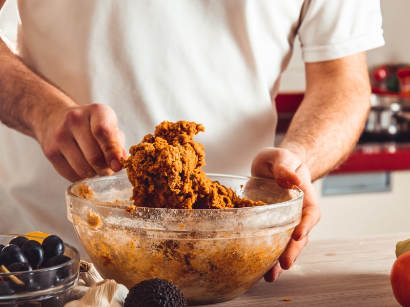 Seitan selbst machen: Ein Mann knetet Seitanmasse in einer Schale.